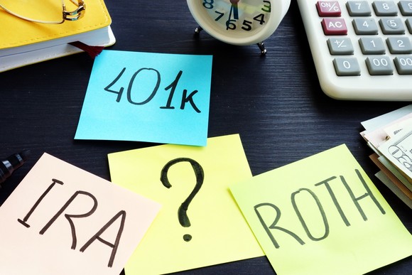 Sticky notes on a desk reading 401k, IRA, Roth, ?.
