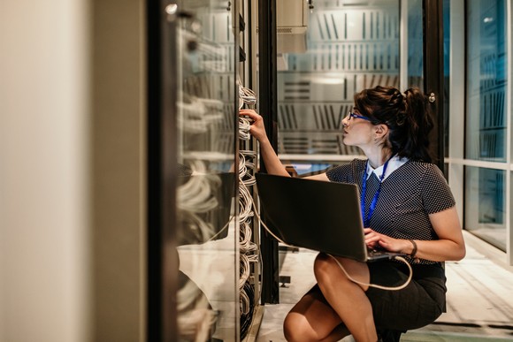 Cloud computing IT technician in server room.