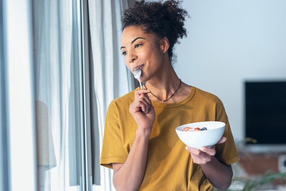 A young person eating cereal from a bowl.