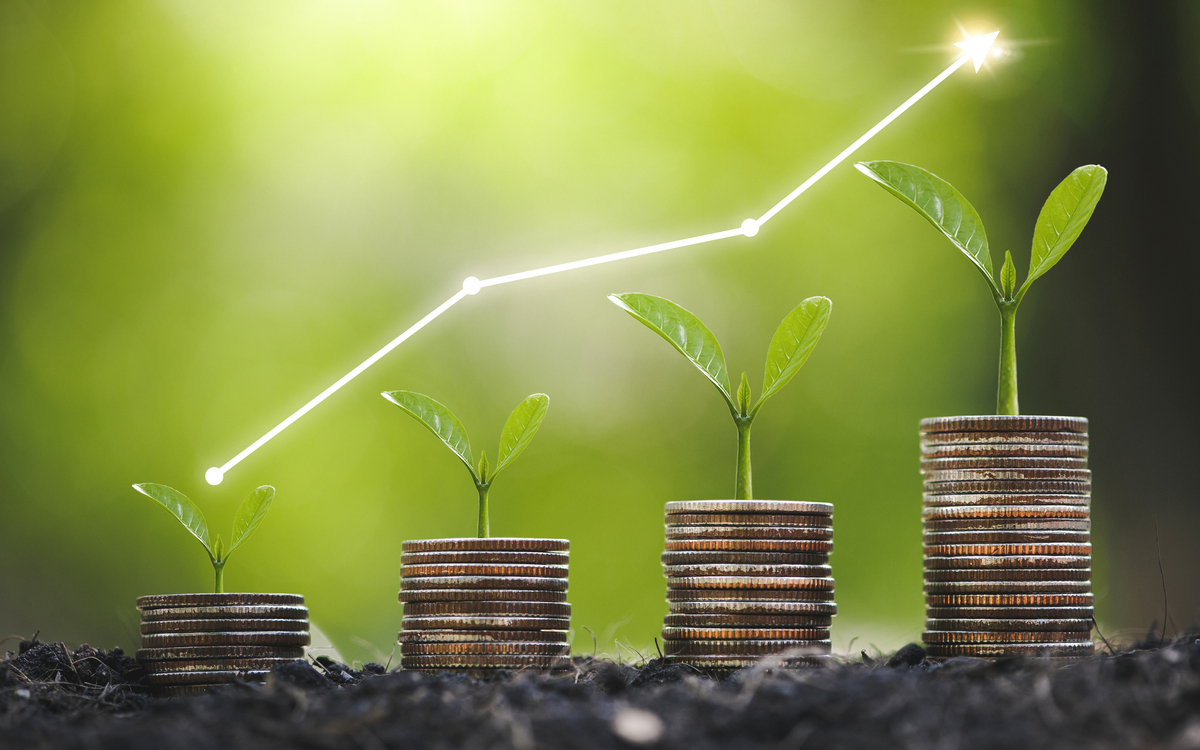 An upward trending line over a stack of coins indicating growth.