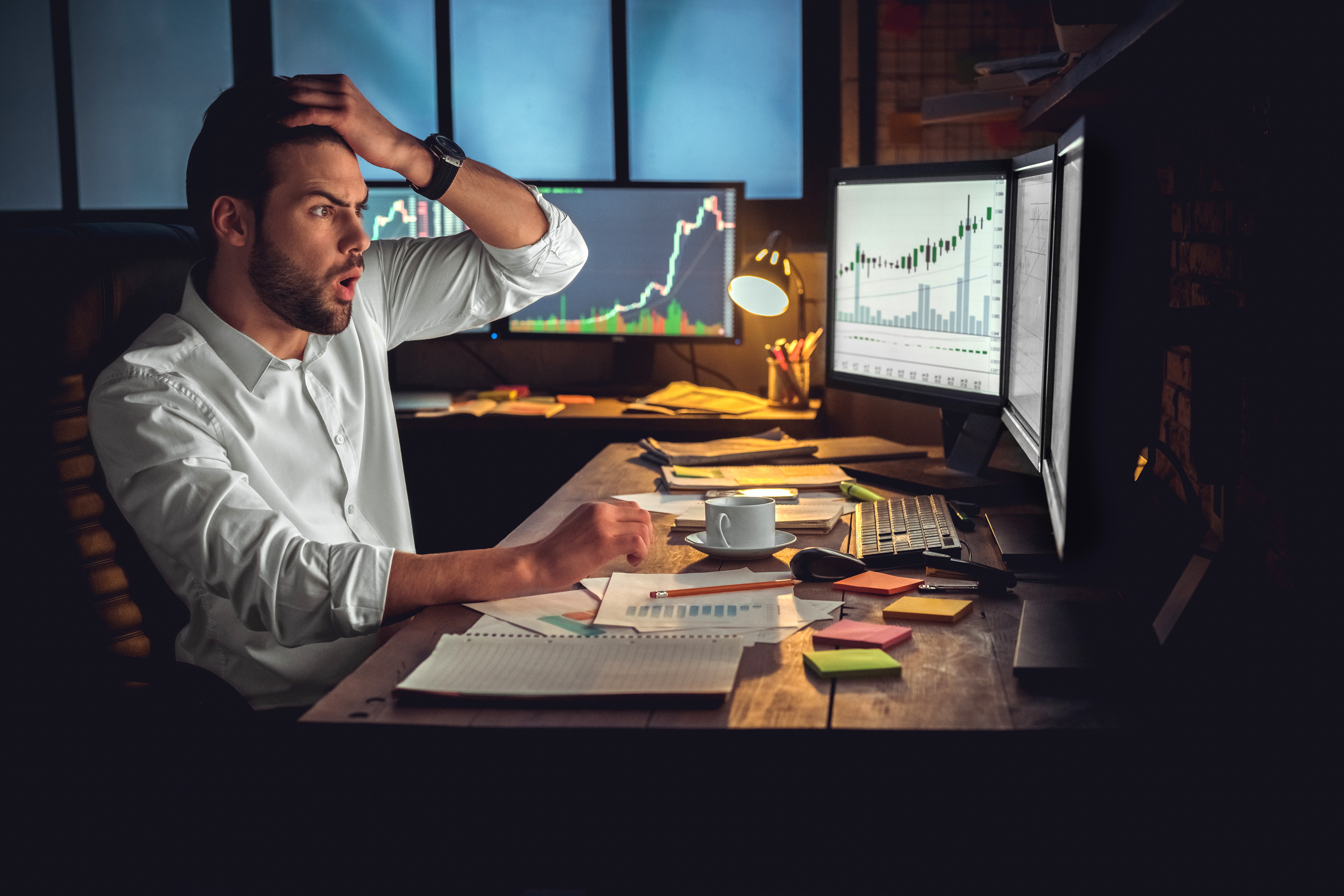 Person holding head in disappointment while looking at computer.