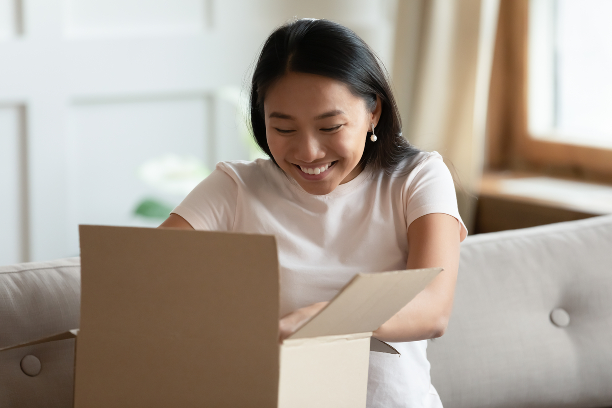 Person smiling while opening a package. 