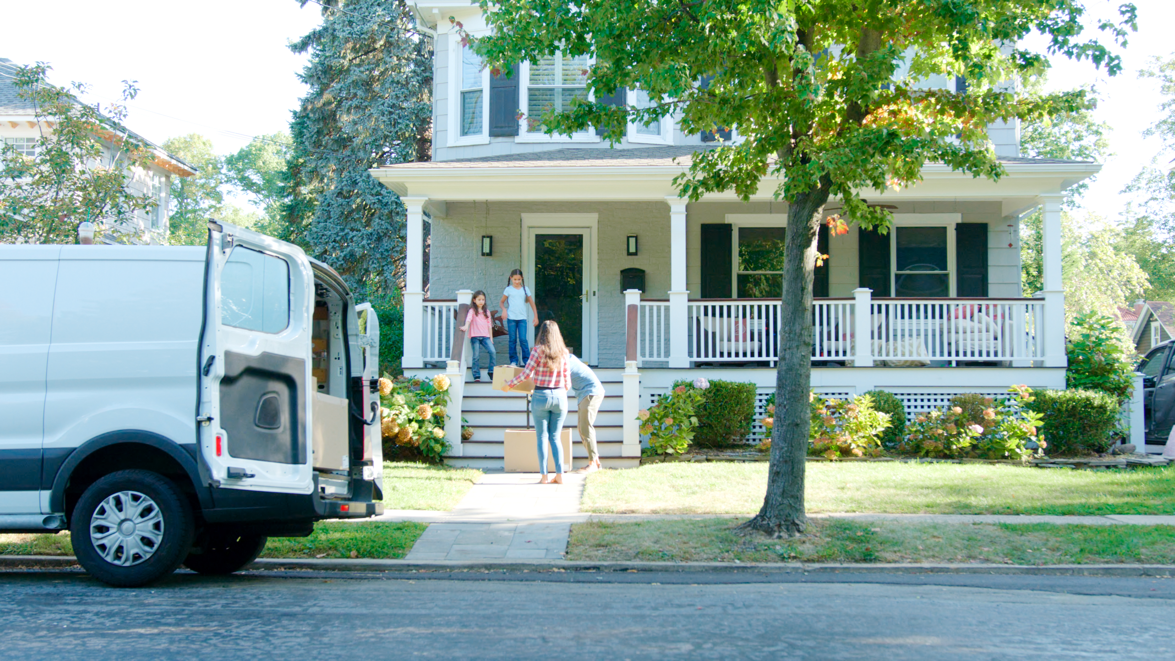 A moving van in front of a house.