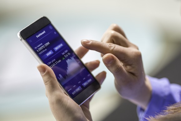 A person summitting a stock order on a mobile device.