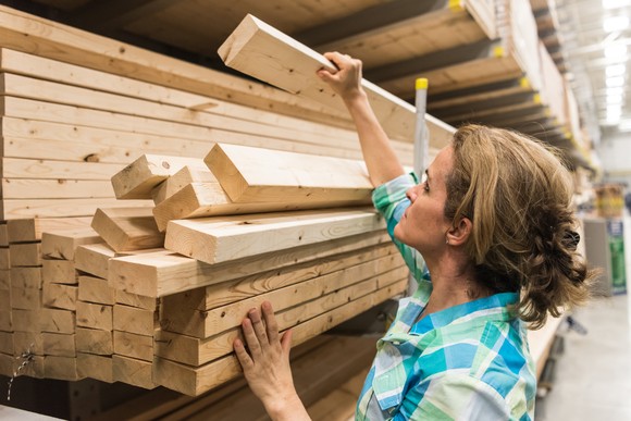 Person going through a lumber selection inside a store.
