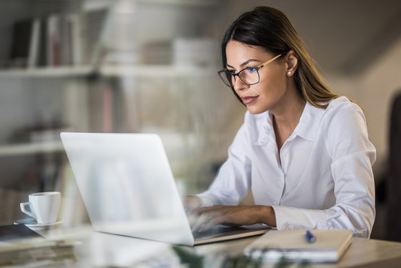 An investor studies something on a laptop.
