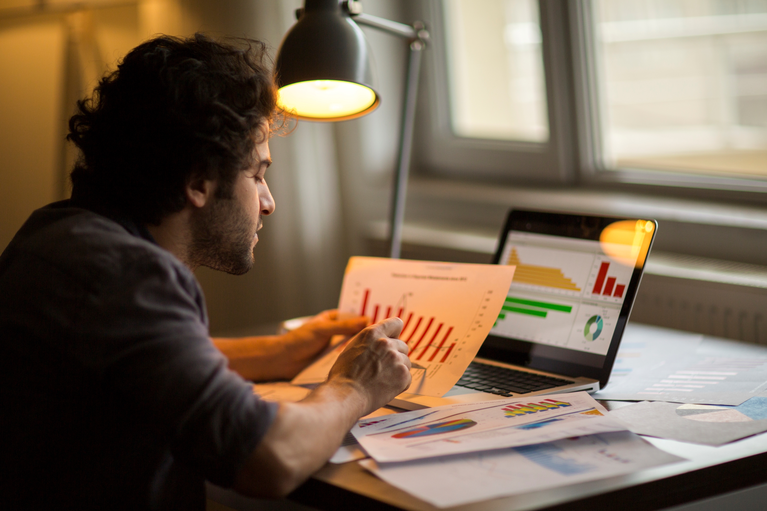 Investor at home looking at multiple charts.