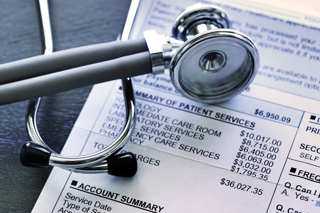 A stethoscope lying on top of a medical bill.
