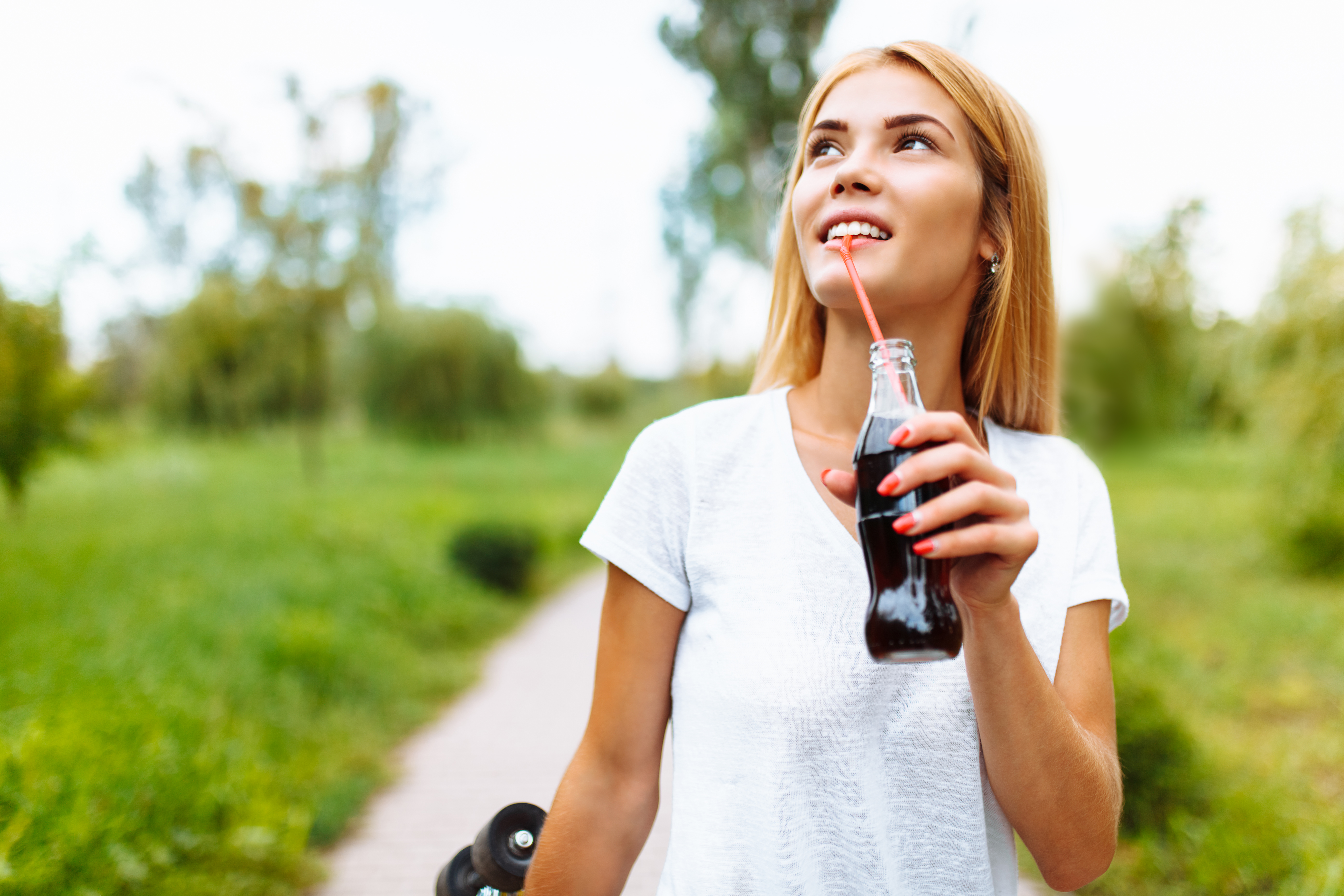 Person drinking bottled drink with a straw