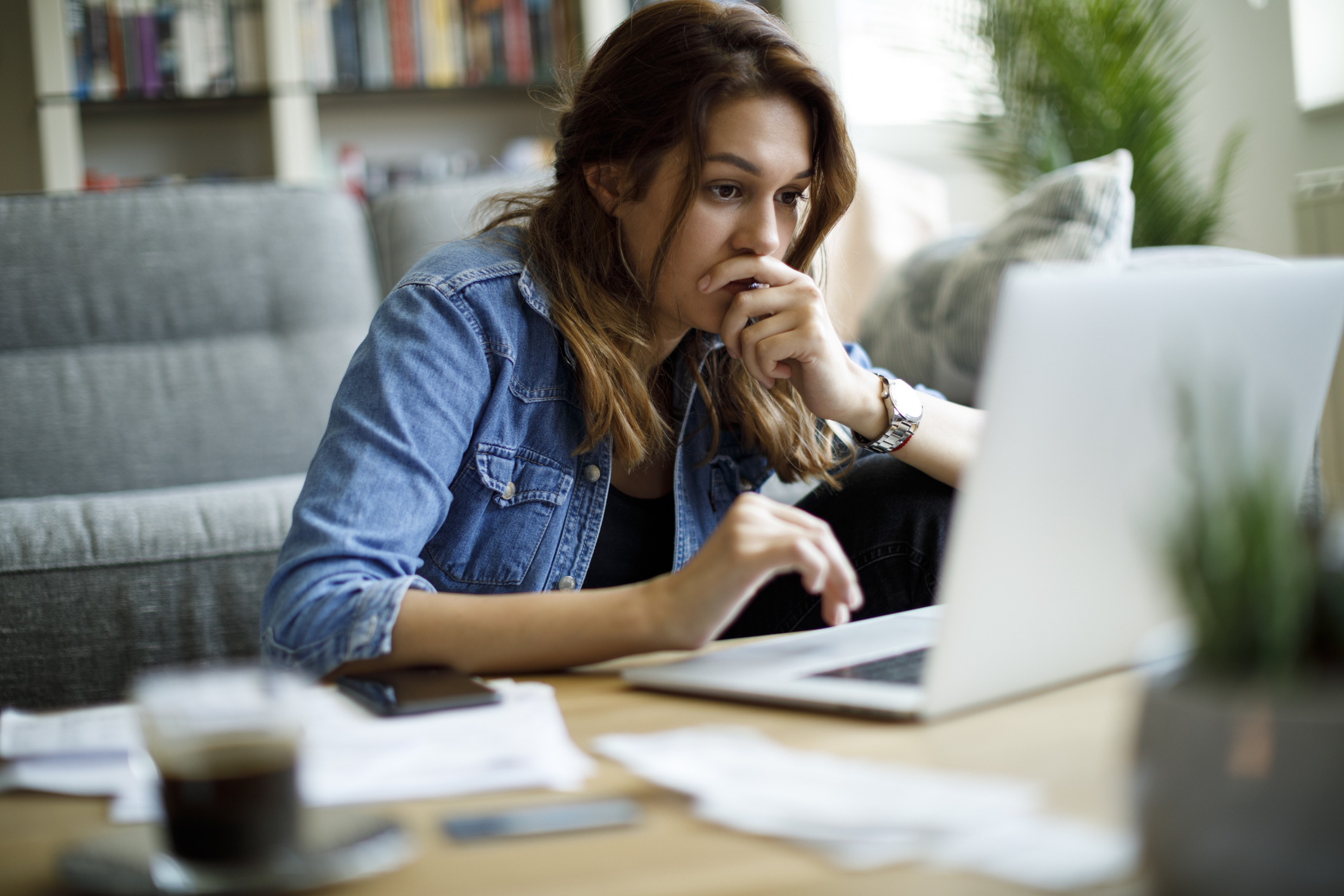 investor-looks-worried-at-computer-in-a-living-room-setting-getty