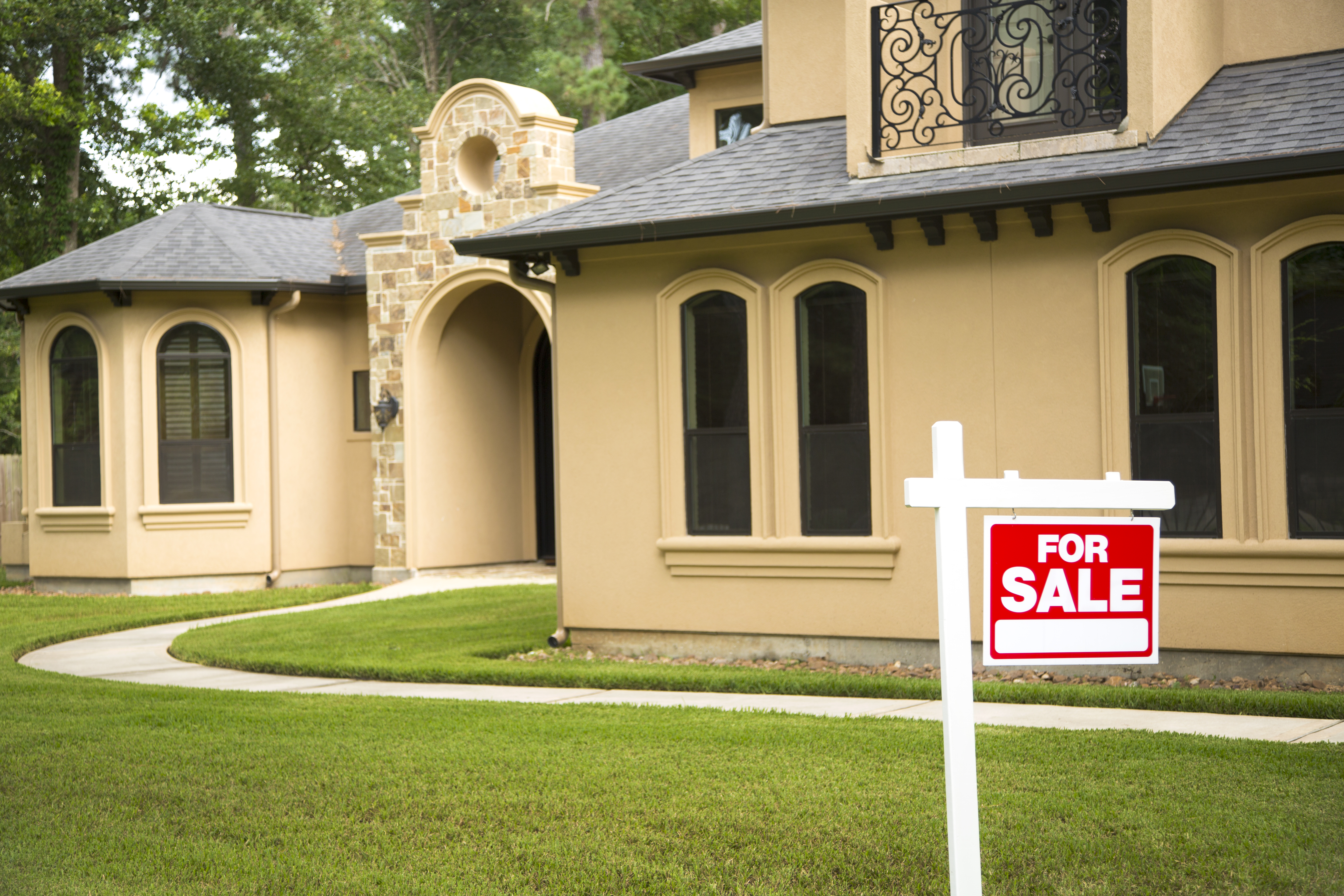 House with "For Sale" sign in front yard.