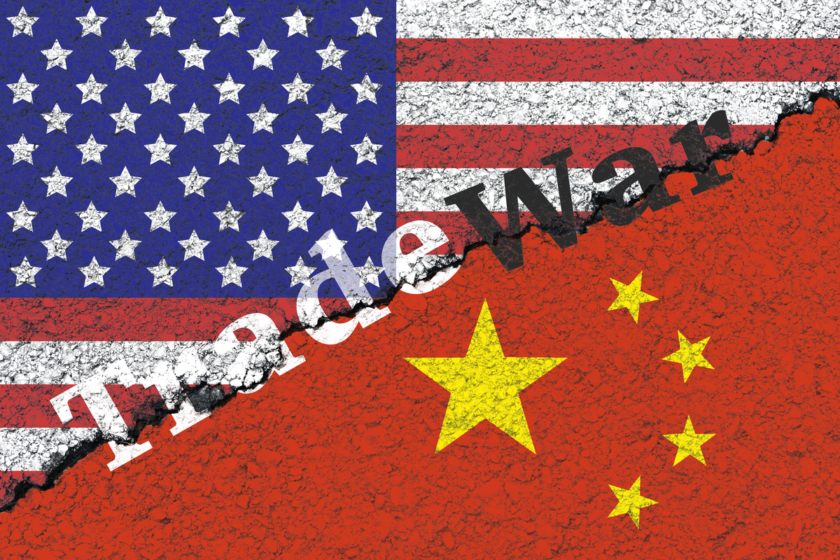 US-China trade war depiced as two halves of a flag with a crack down the middle.