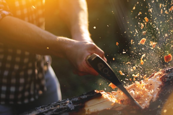 Logger chopping a tree with an axe.