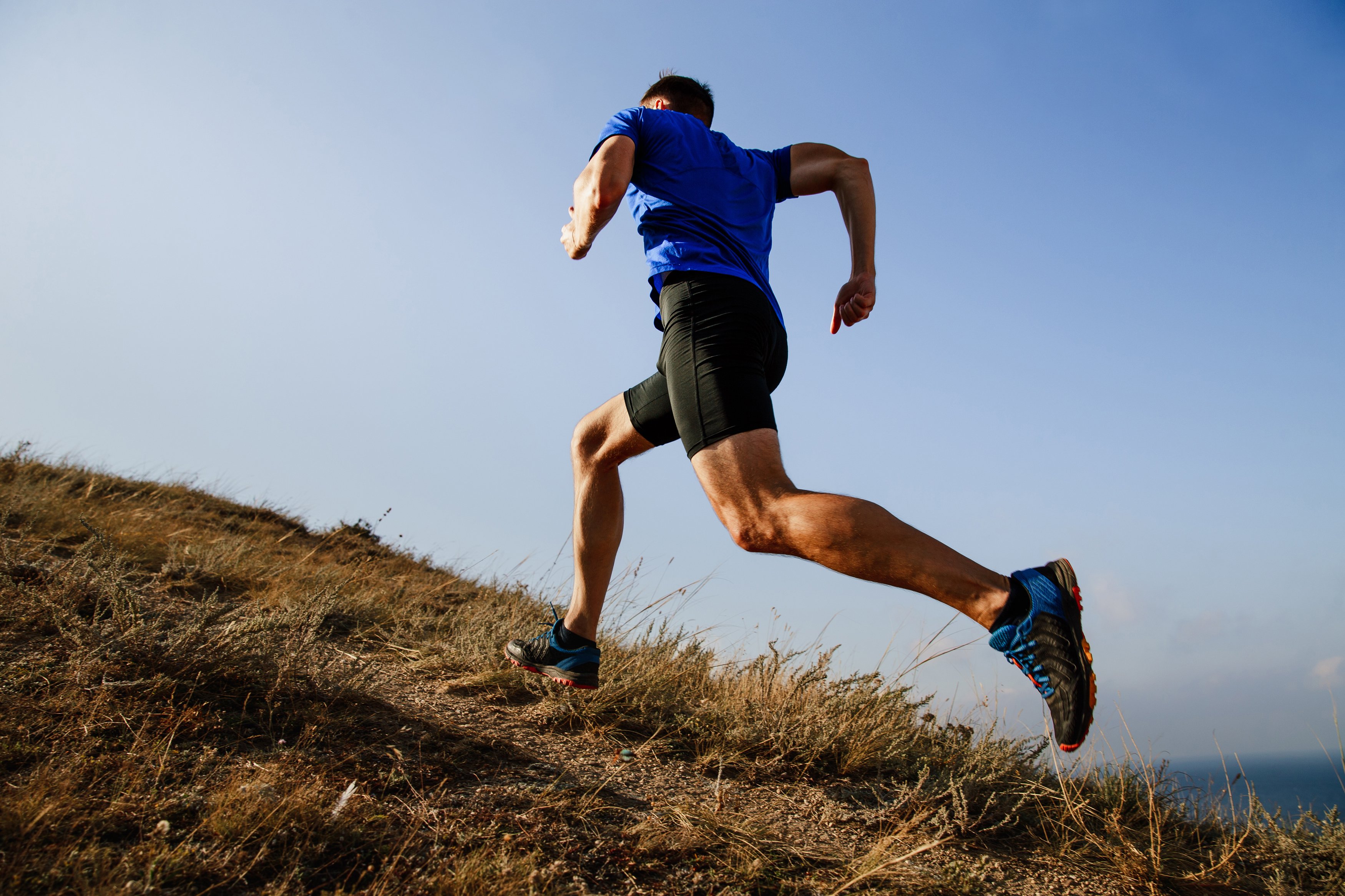 A man running uphill on a trail outside