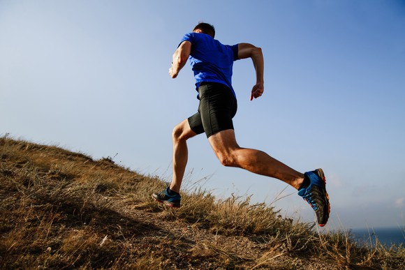 A man running uphill on a trail outside