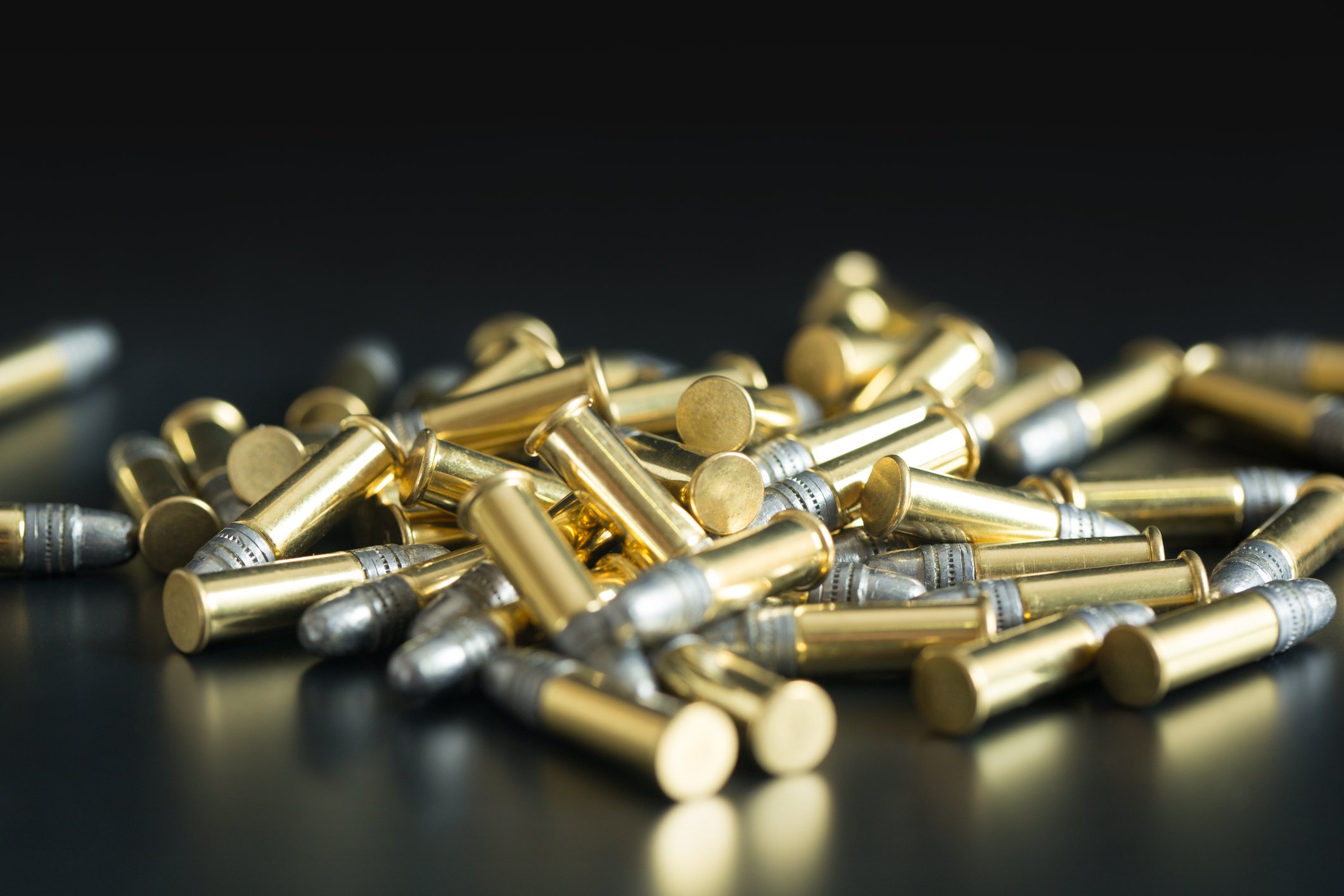 Pile of .22-caliber bullets on black background
