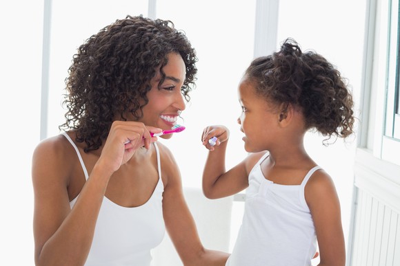 Mother and daughter brushing their teeth