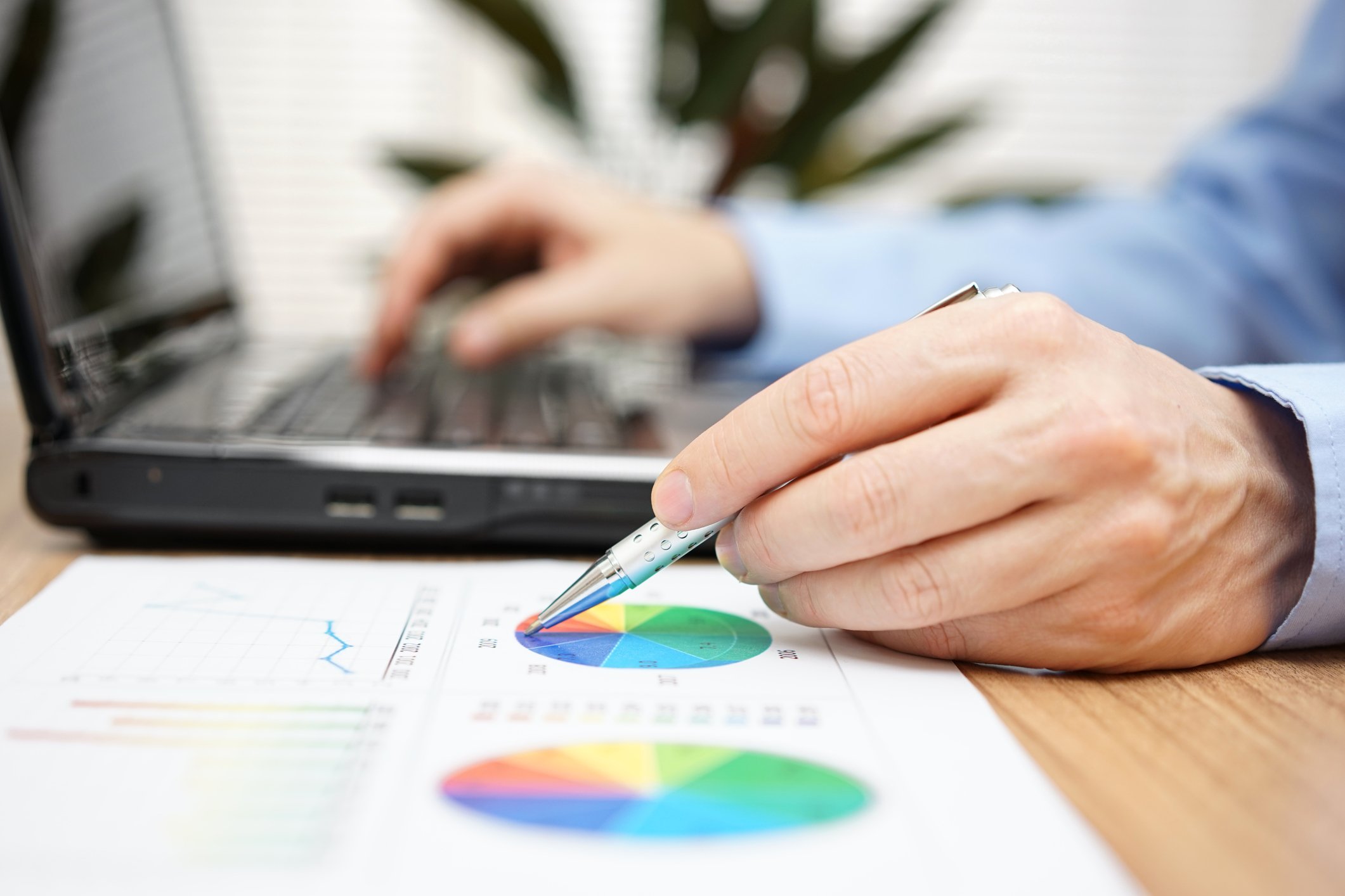 Man working on laptop and doing paperwork.
