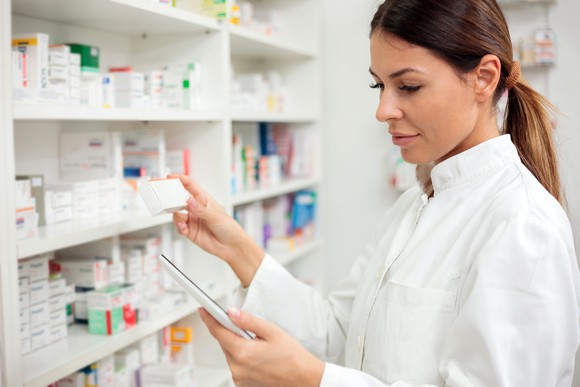 Female pharmacist takes drugs off a shelf