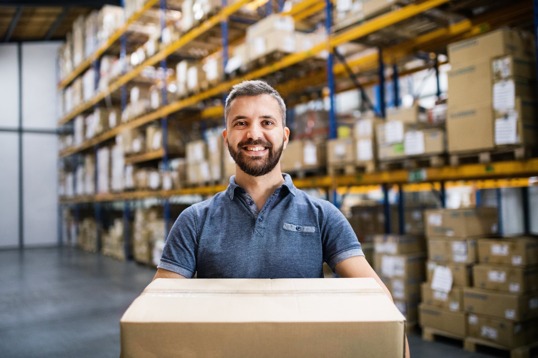 A smiling man holding a box at a warehouse store