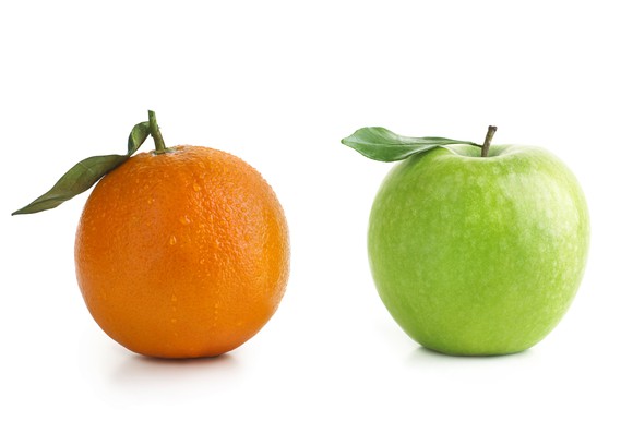 An orange and a green apple compared side by side.
