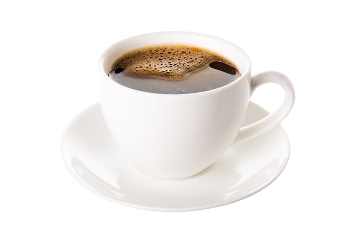Coffee in a white mug on a white saucer.