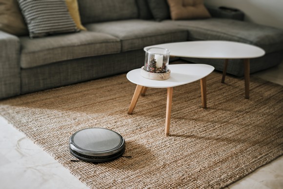 A robotic vacuum working on the floor in a living room