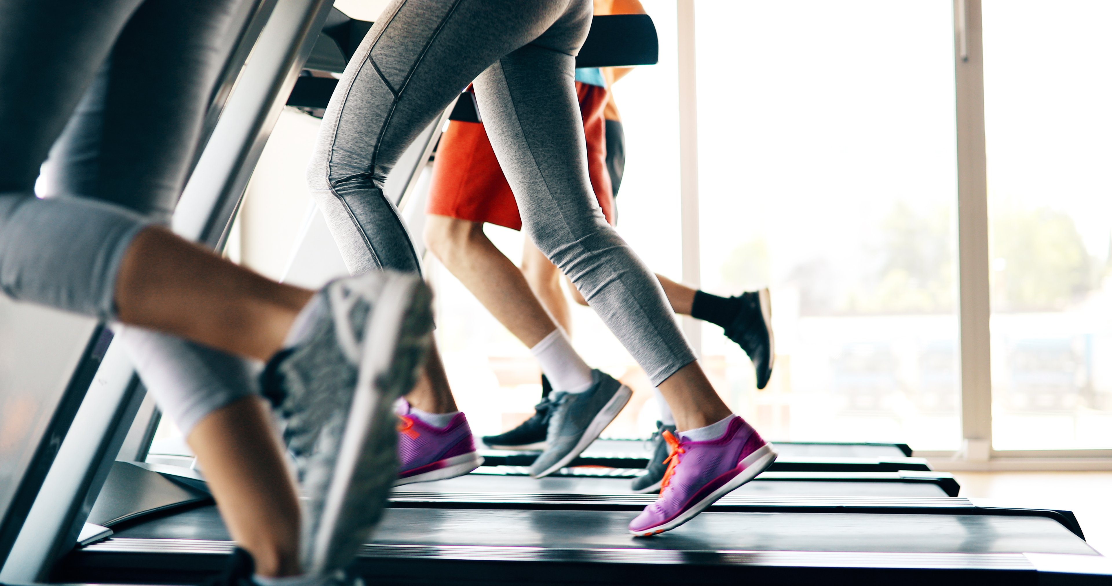 A waist-down view of people running on treadmills