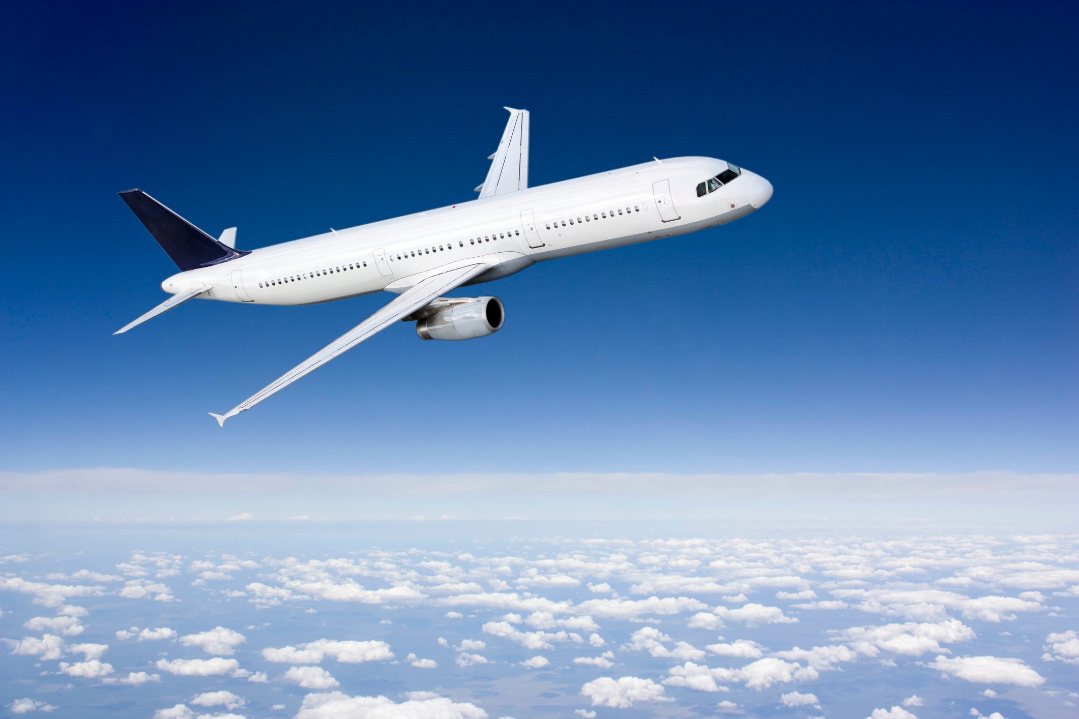An airplane flying through blue skies.