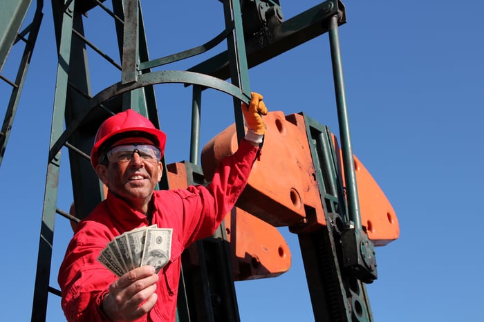 An oil worker holding cash