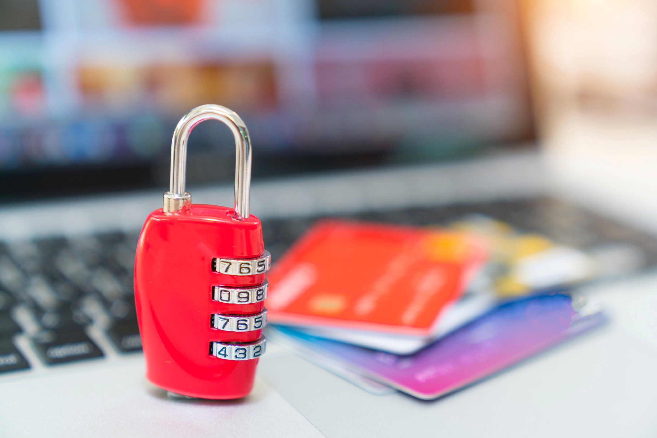 A padlock protects credit cards on a laptop keyboard.