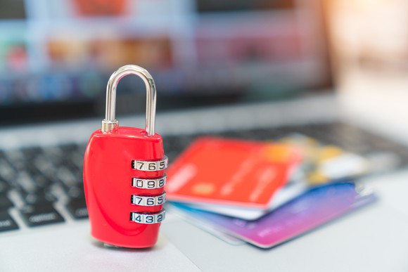 A padlock protects credit cards on a laptop keyboard.
