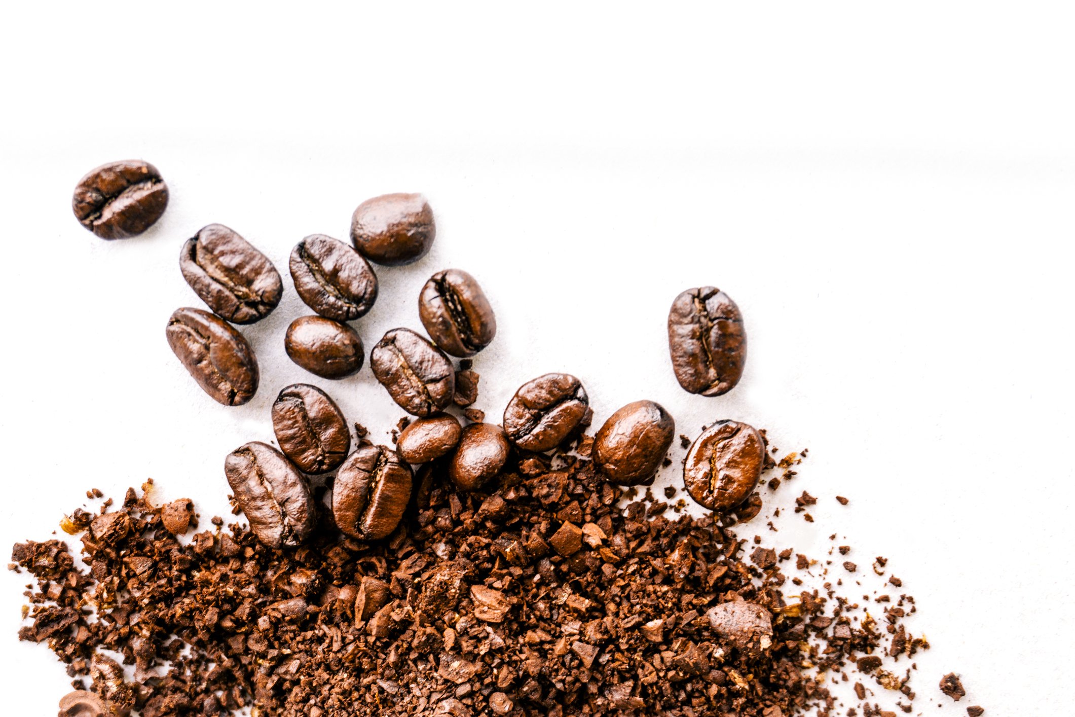 Several coffee beans, with some ground up