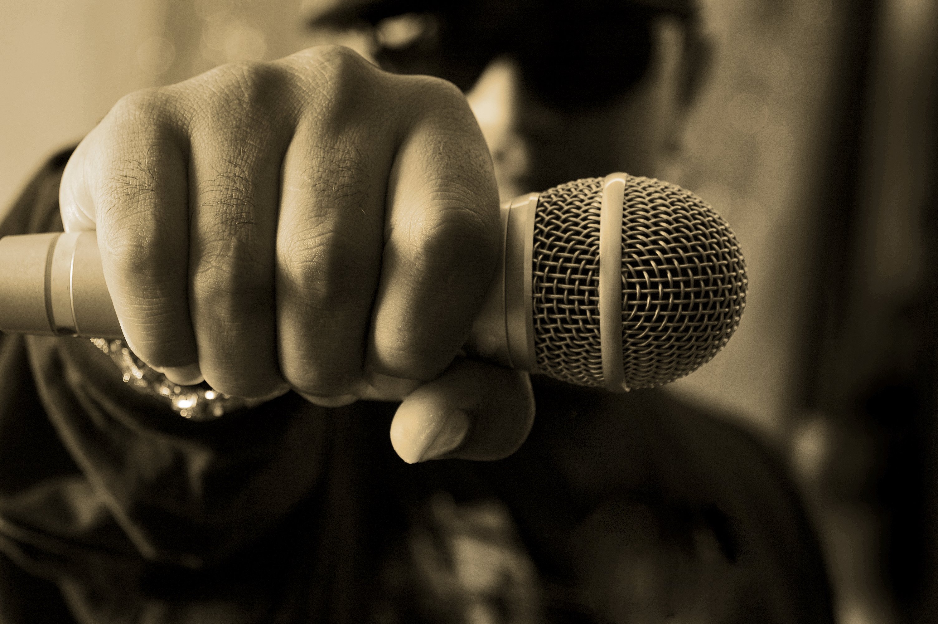 Close-up of a rapper's hand as he prepares to drop the mic.