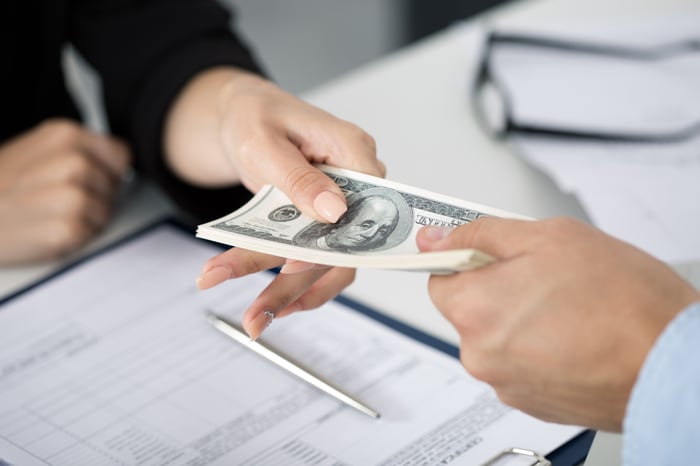 Stack of money changing hands.