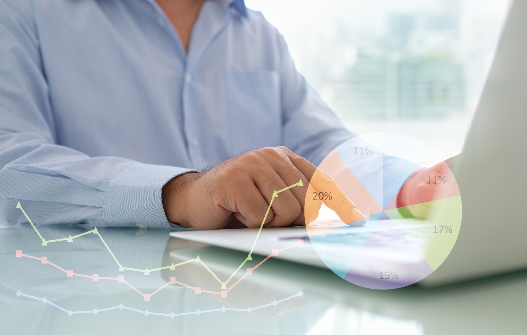 A man on a laptop, with a pie chart superimposed