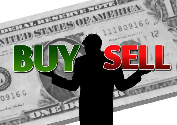 man in silhouette with arms outstretched, weighing the words "buy" and "sell" and standing in front of a big, projected dollar bill