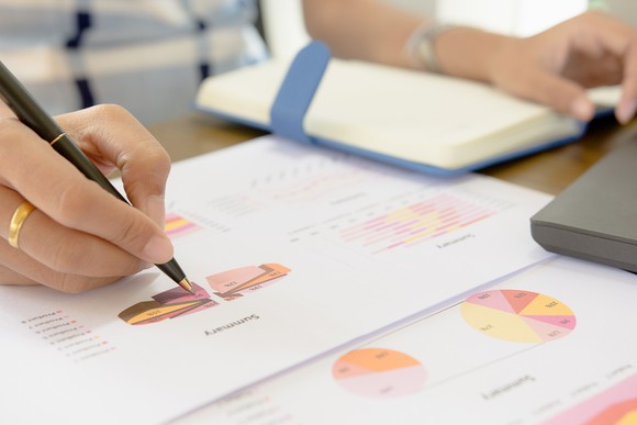A woman checks a budget pie chart.