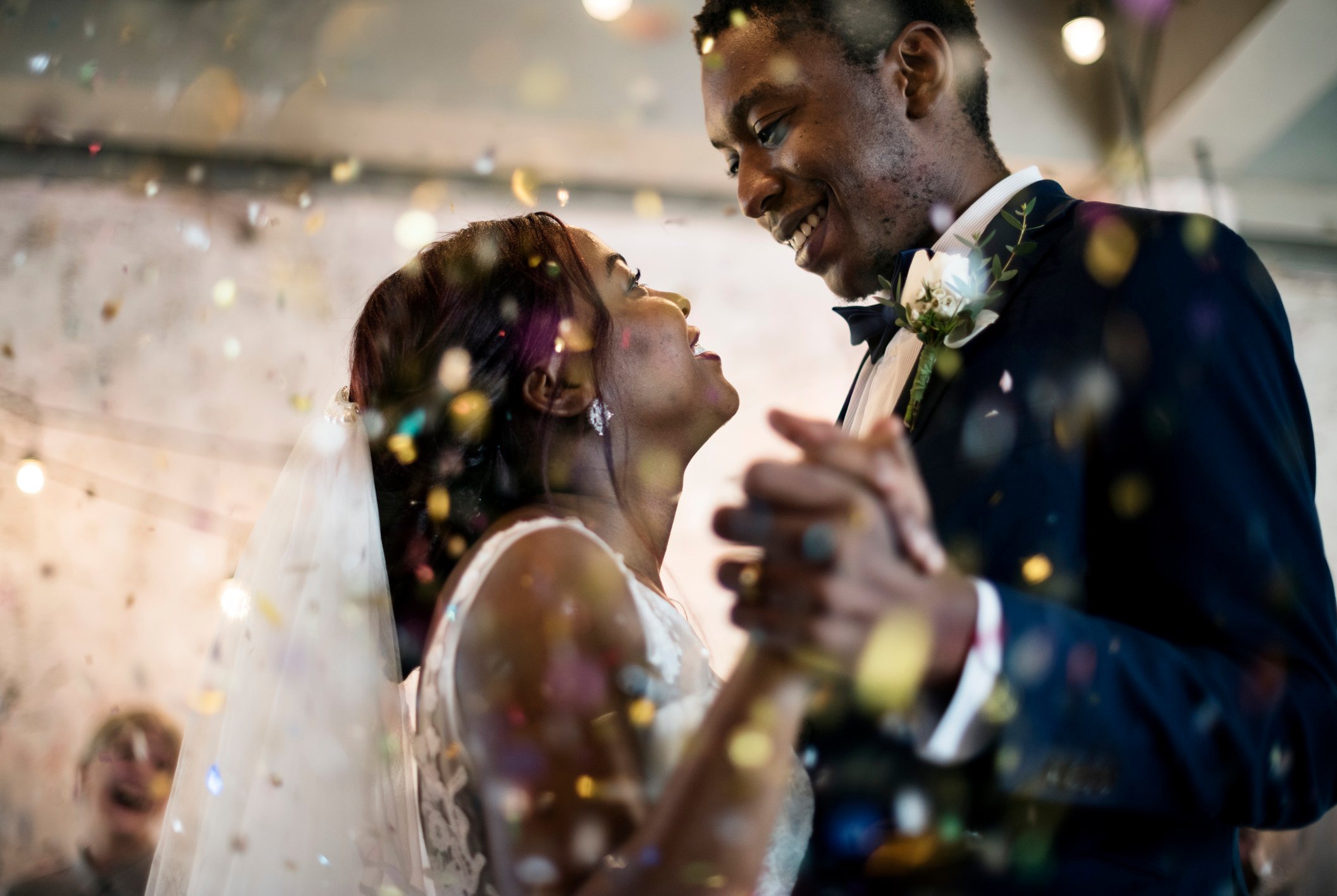 Smiling newlyweds dancing at their wedding reception.