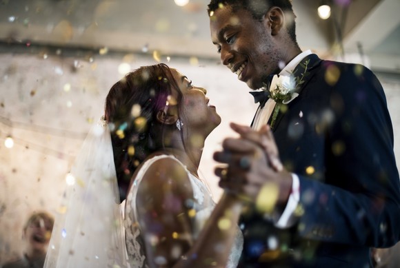 Smiling newlyweds dancing at their wedding reception.