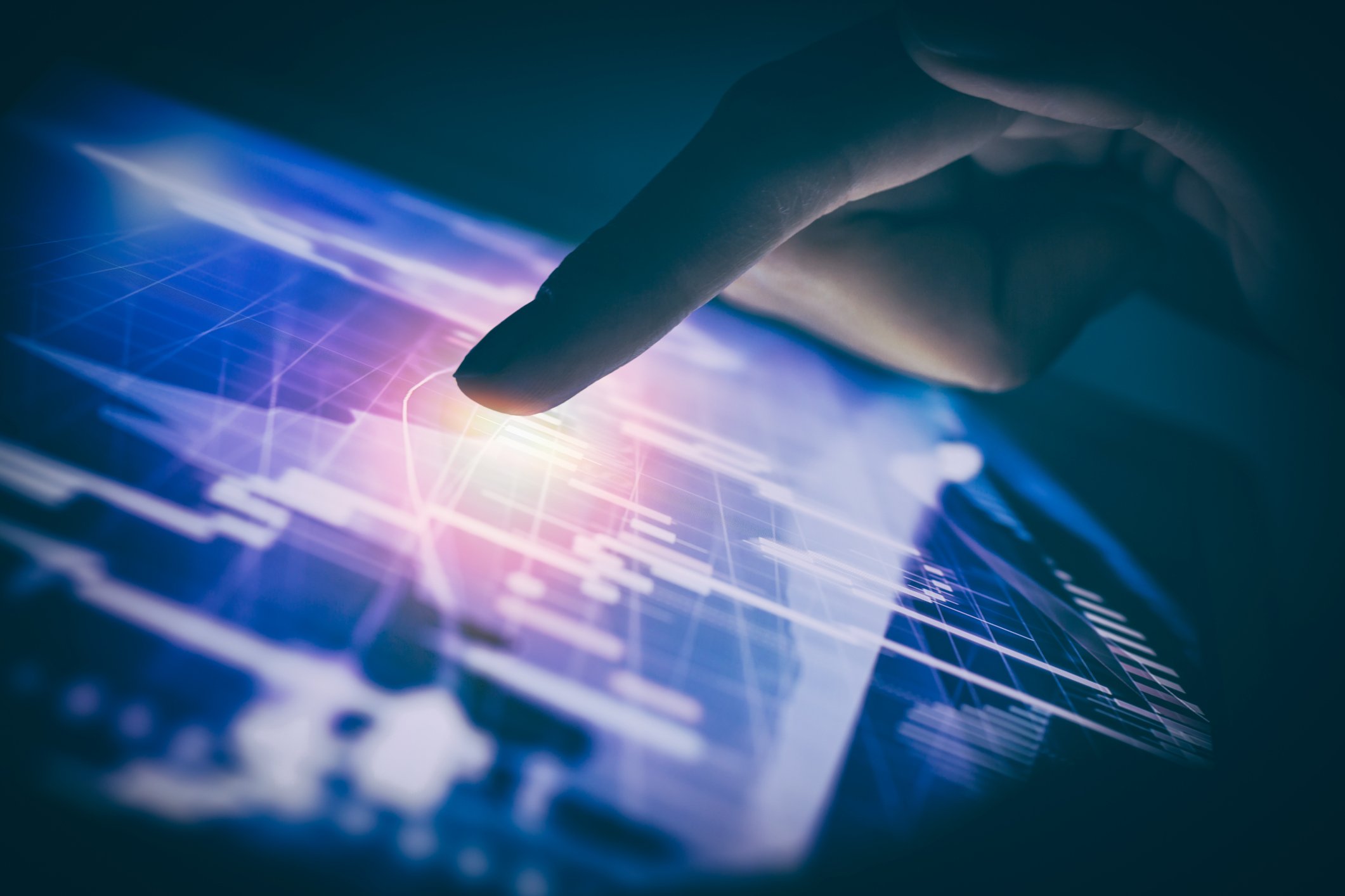 Finger pointing to candlestick chart on a tablet screen