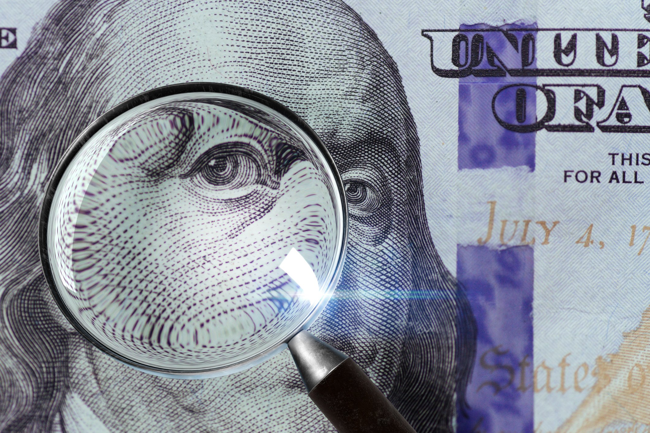 A 100 U.S. bill under a magnifying glass