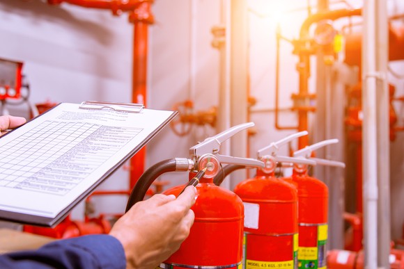 Engineer with a clipboard checking a building's fire control system