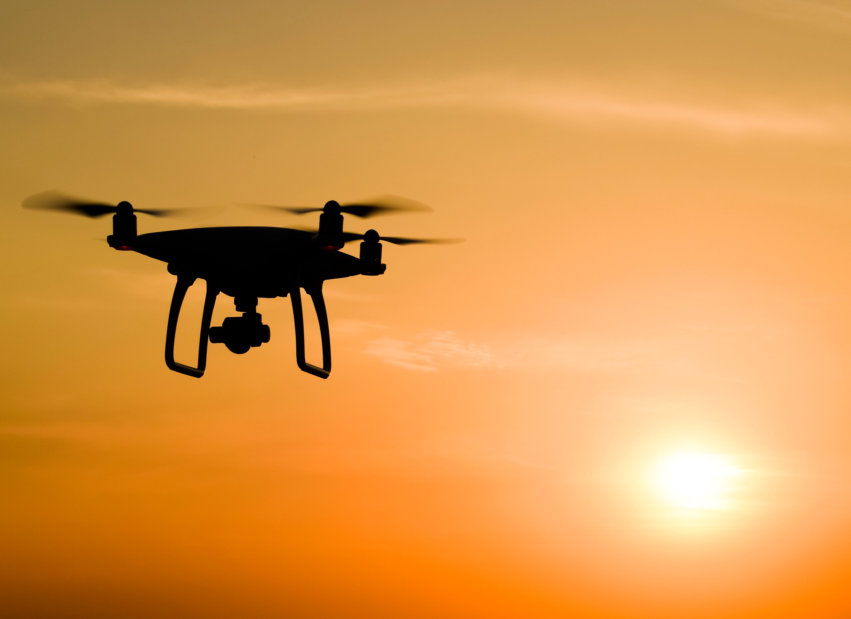 Silhouette of a drone with sun setting in the background