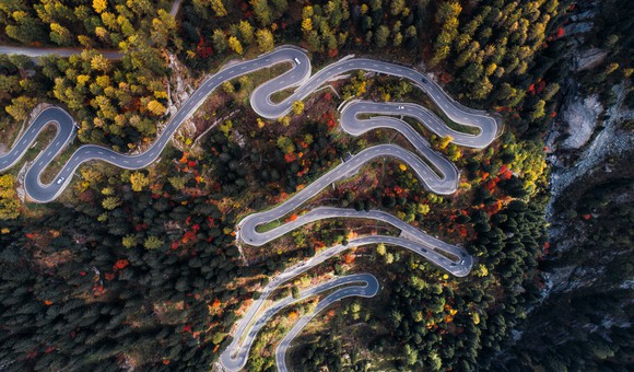 Drone footage of a road winding through a forest