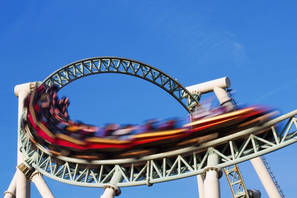 A roller coaster blurred by speed exits a loop