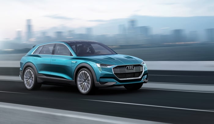 Audi's e-tron quattro concept SUV is shown on a desert landscape.