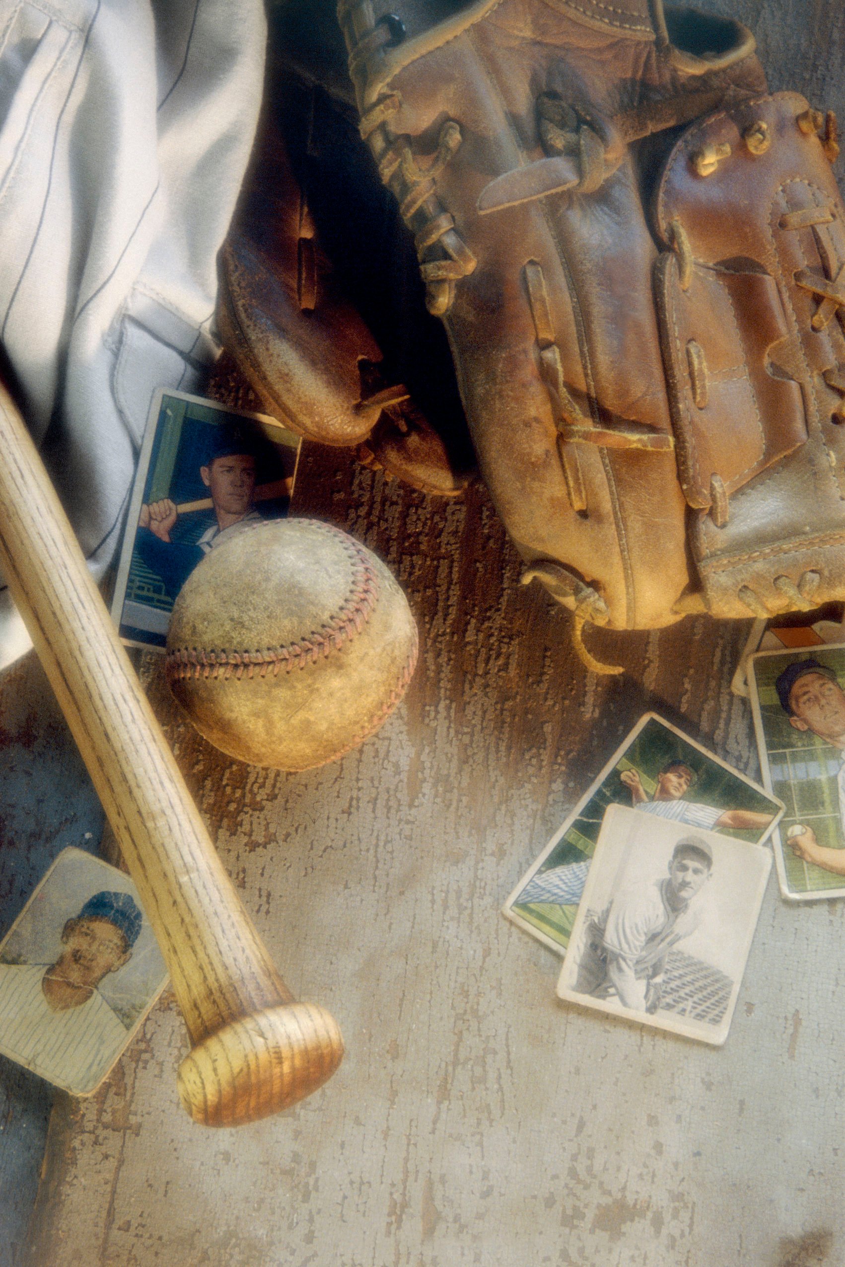Old baseball cards with a bat, ball, and glove.