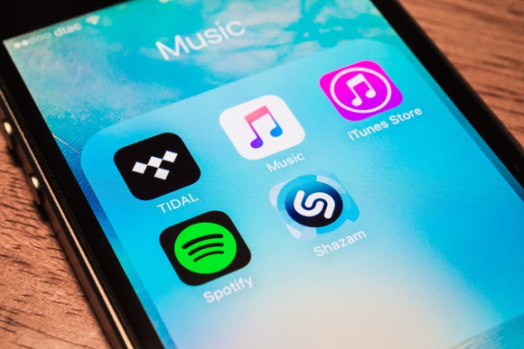 An image of an iPhone screen featuring several prominent streaming music apps including Spotify, Pandora, Apple Music, and more.