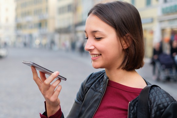 A woman uses the voice-activated assistant on her mobile phone.